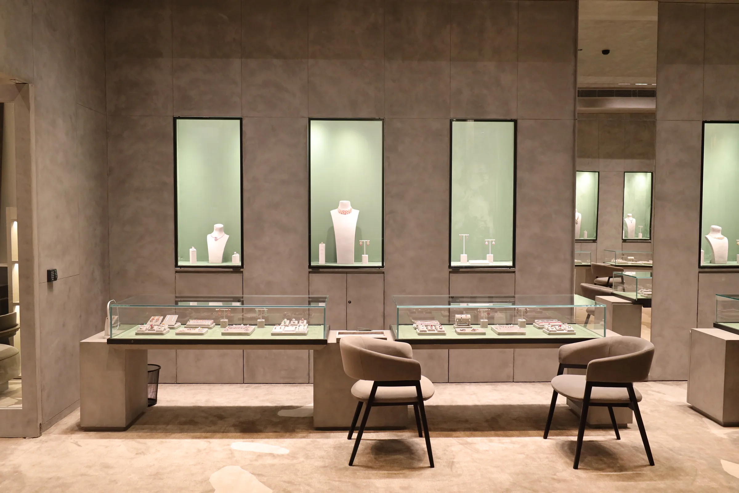 The main salon at Gem Plaza, lit wall vitrines above a long counter with seating
